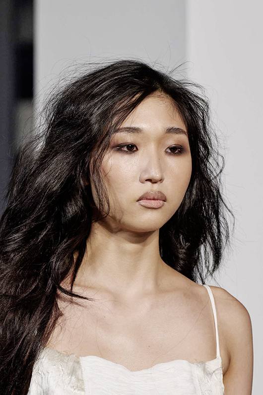 Азиатская модель с лёгким дымчатым макияжем глаз и натуральными губами, текстурные волосы, деликатный образ в стиле афтепати.