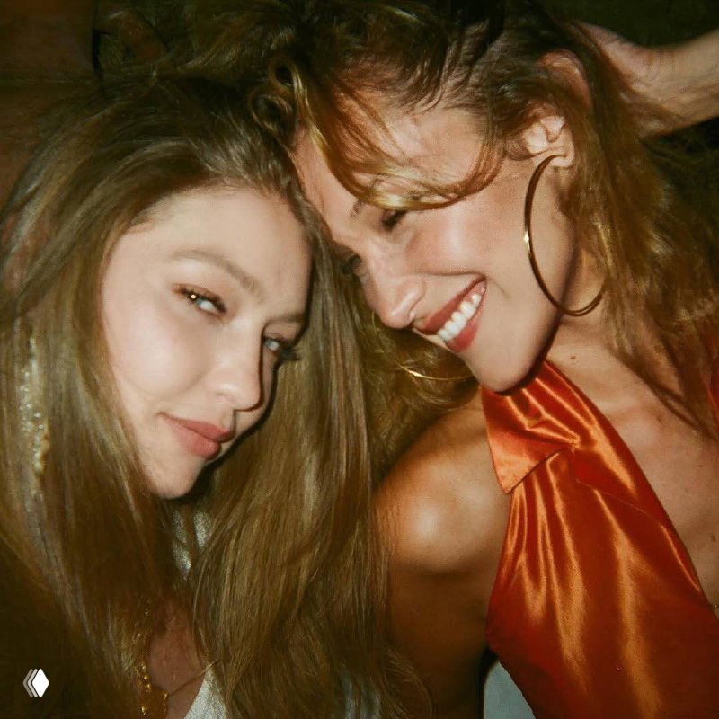 Крупный план двух женщин, улыбающихся в кадре при ночном освещении; атмосферный снимок со счастливыми лицами и близким ракурсом.
