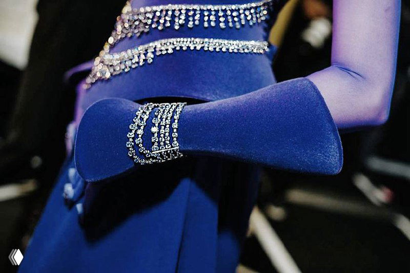 Крупный план синего наряда с перчаткой и инкрустацией кристаллами у запястья, иллюстрация акцента на синих аксессуарах.