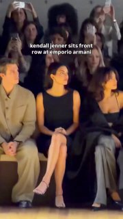 Короткое вертикальное видео: Кендалл Дженнер сидит в первом ряду показа Emporio Armani, рядом другие гости, кадр снят с телефона.