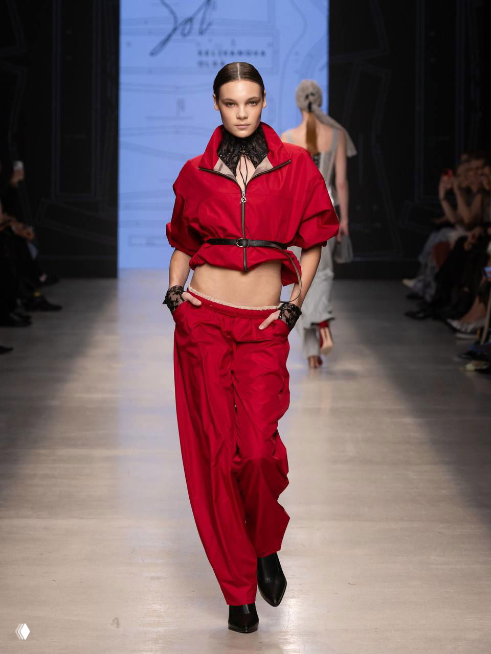 Яркий спортивный костюм красного цвета на модели — свободный крой, акцент на уличной эстетике и костюмной линии.