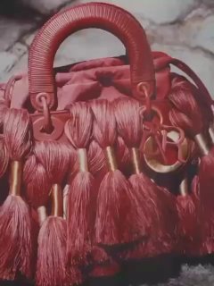 Крупный план сумки Dior с кисточками и текстурными деталями — предметная фэшн‑фотография из нового журнала, демонстрация аксессуаров.