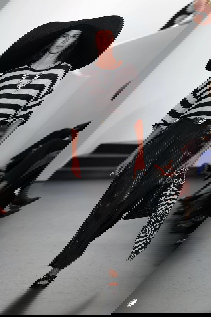 Черно‑белая полоска в широком принте на свободном топе, дополненная большой шляпой и аксессуарами — напоминание о зонтах и шезлонгах.