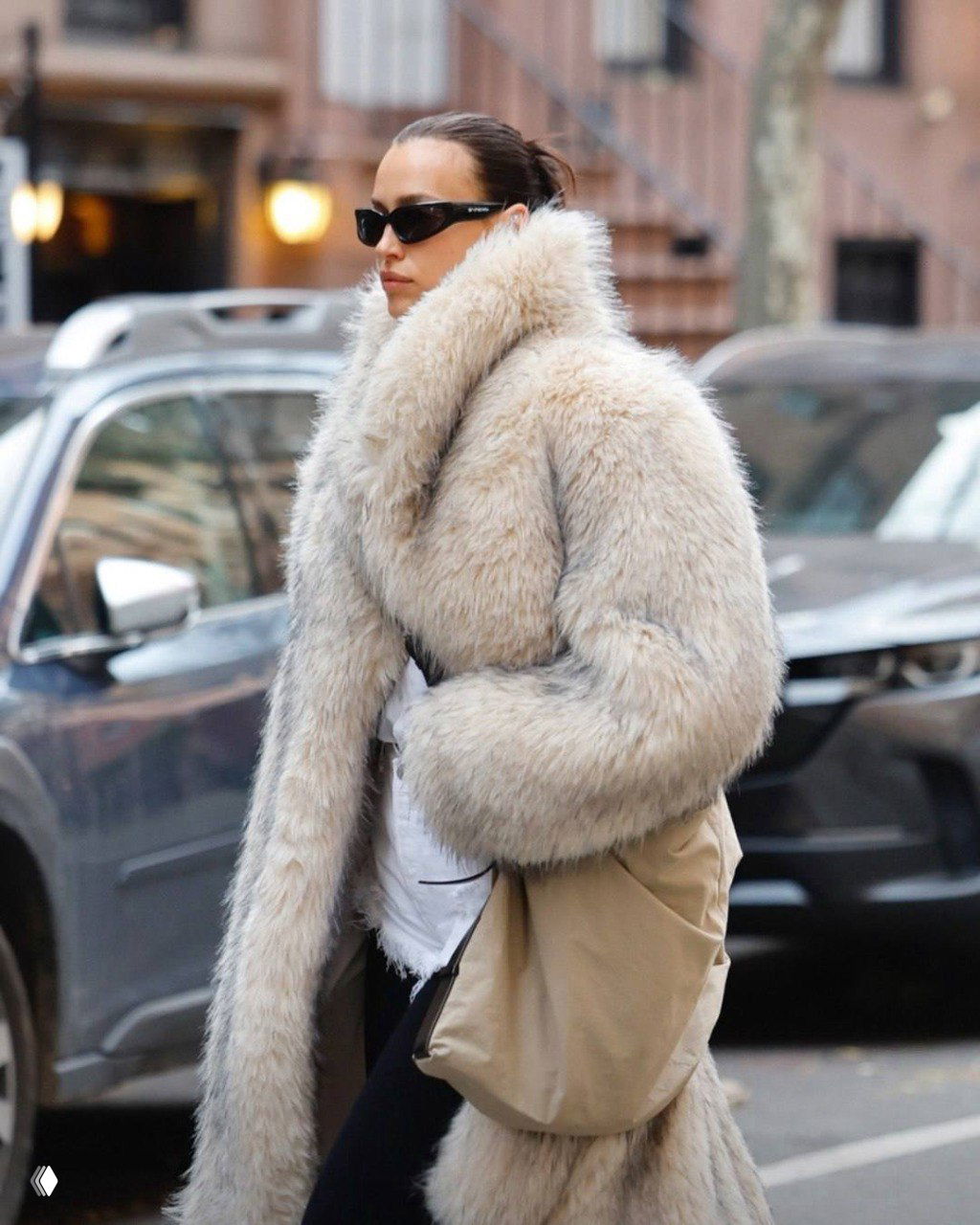Крупный план: женщина в объёмной белой шубе, тёплый воротник и аксессуары сочетаются в городском стритстайл‑луке.