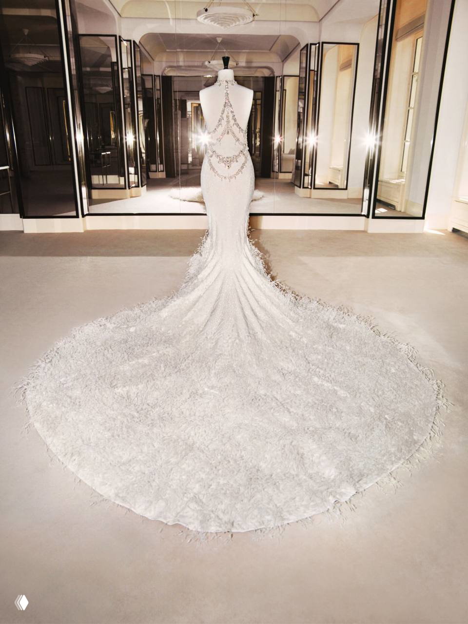 Шлейф свадебного платья Chanel, широко разложенный на полу студии, видно перьевые и кружевные элементы отделки