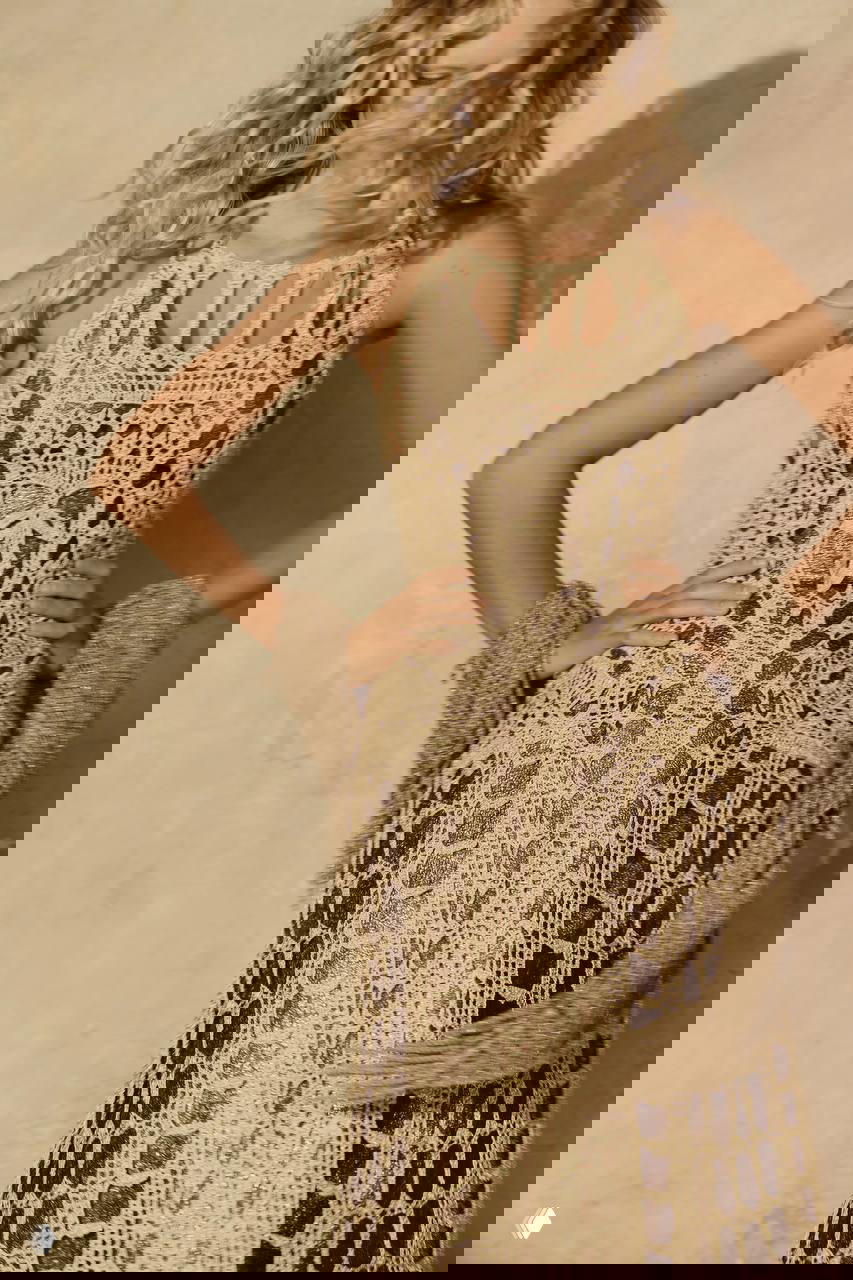 Крупный план силуэта в ажурном вязаном платье — детальная текстура работы ручной вязки и естественные локоны модели, эстетика бохо и лето.