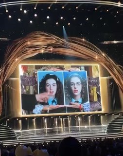 Широкий кадр сцены D23 с большим экраном и показом кадров из фильмов Disney во время фан‑события в Анахайиме, праздничное оформление церемонии