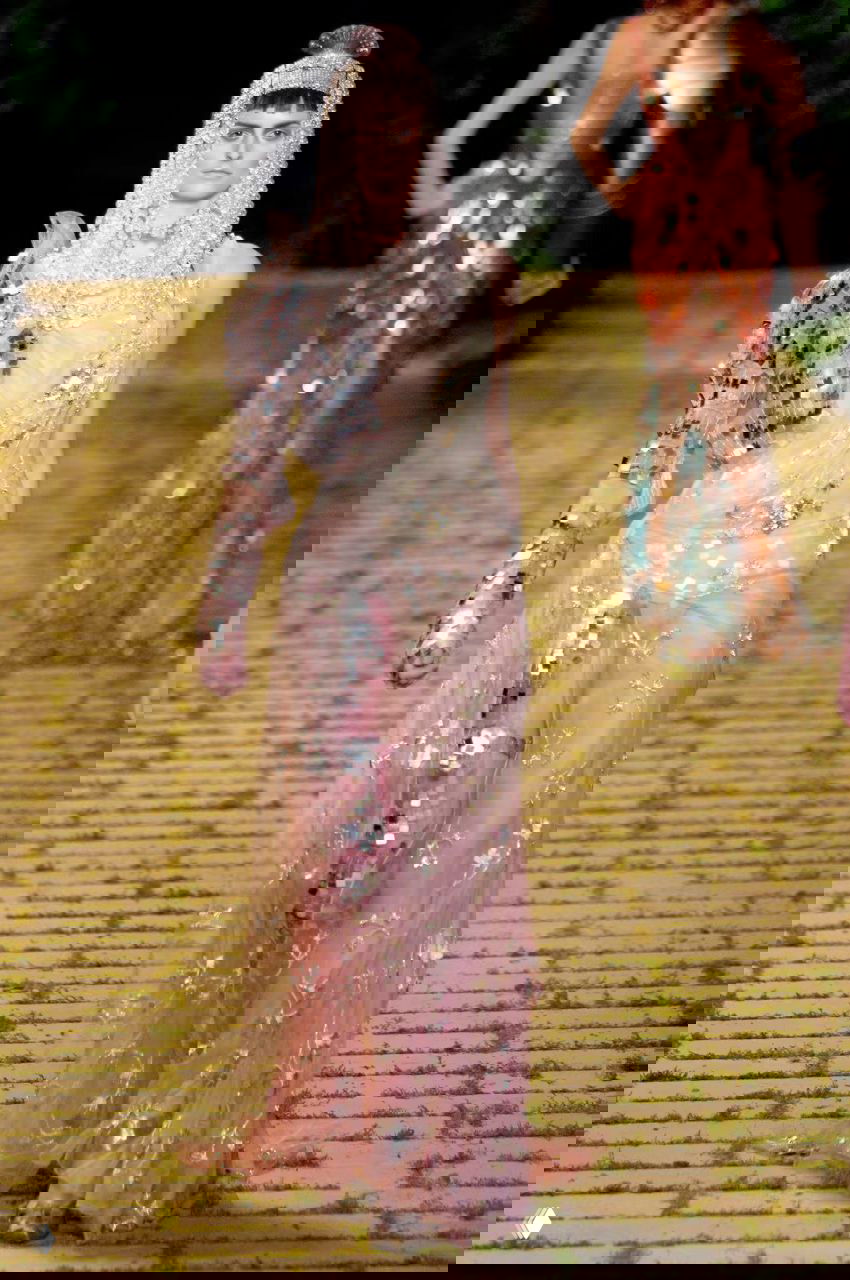 Модель в полупрозрачном розовом платье Dior 2006 с пайетками и декоративной рукавной деталью, сочетание нежности и военной эстетики на подиуме.