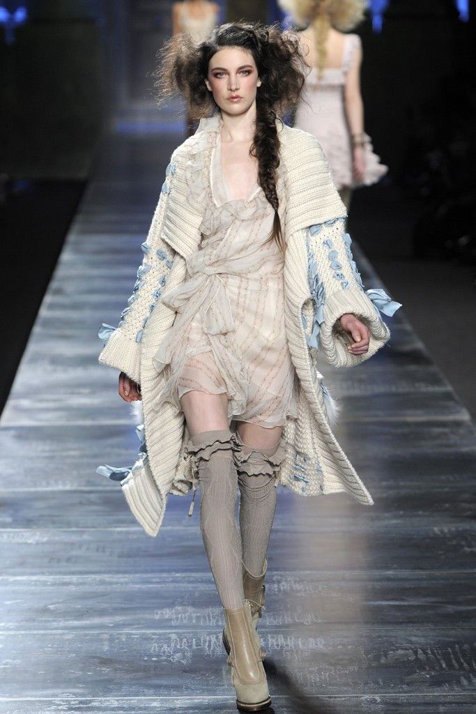 Модель в объёмном вязаном пальто и свободном платье шагает по подиуму — сочетание рустикальной вязки и лёгких материалов у Dior 2010.