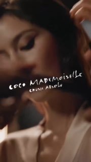 Кадр рекламного ролика Coco Mademoiselle: крупный план женщины в элегантном образе при мягком свете, видна стилизованная надпись бренда.