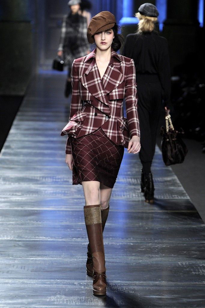 Модель в клетчатом пиджаке и юбке идёт по подиуму — графичные принты и выверенная посадка в коллекции Dior осень‑зима 2010.