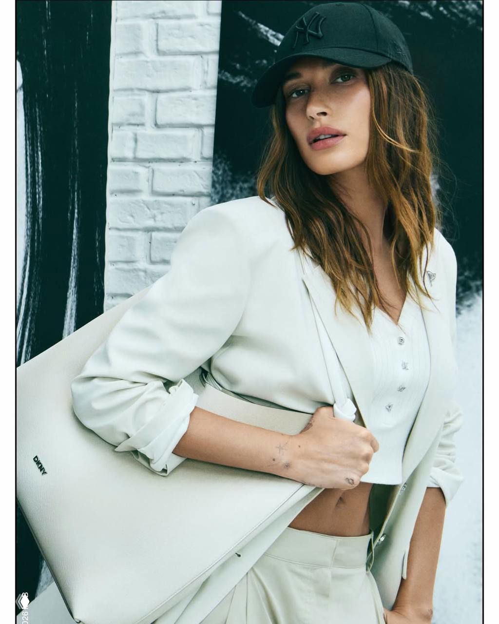 Хейли Бибер в светлом пиджаке и сумкой DKNY: портрет в стиле минимал с акцентом на сумку и текстуру ткани, рекламная съёмка бренда