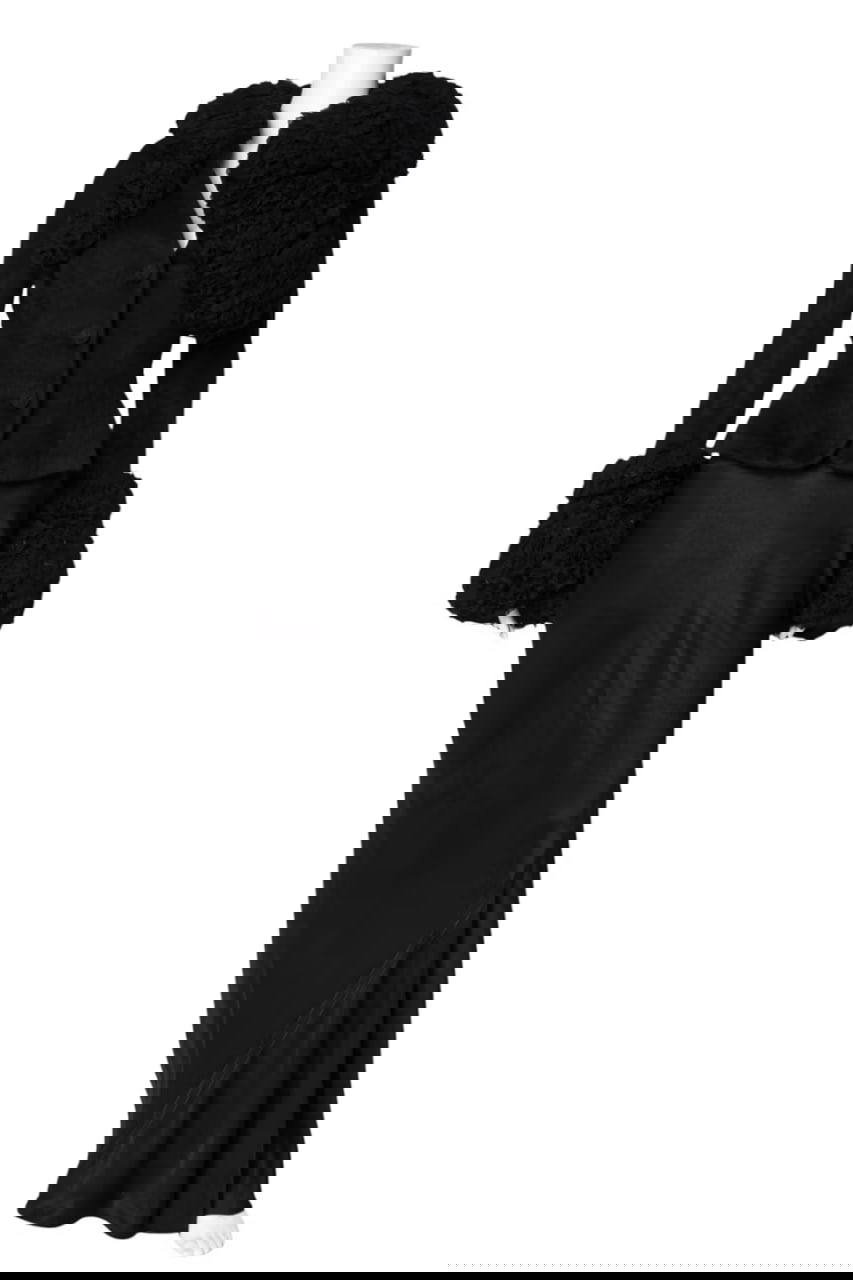 Чёрный винтажный костюм на манекене: приталенный жакет с пушистым воротником и длинная юбка на белом фоне, снимок лота аукциона.