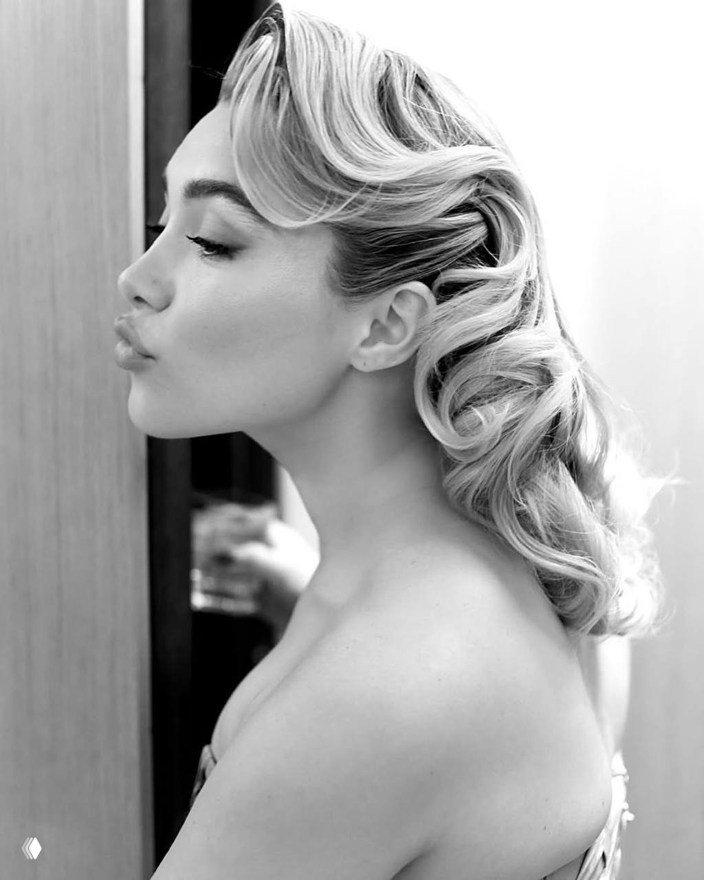 Чёрно-белый портретный снимок женщины в ретро-укладке в профиль — элегантный образ и гладкая причёска на мероприятии.