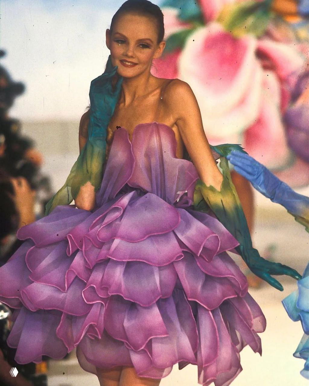 Крупный план модели в цветочном платье Mugler 1982: слоистая структура, нежно‑пурпурная палитра и тонкие декоративные перчатки.