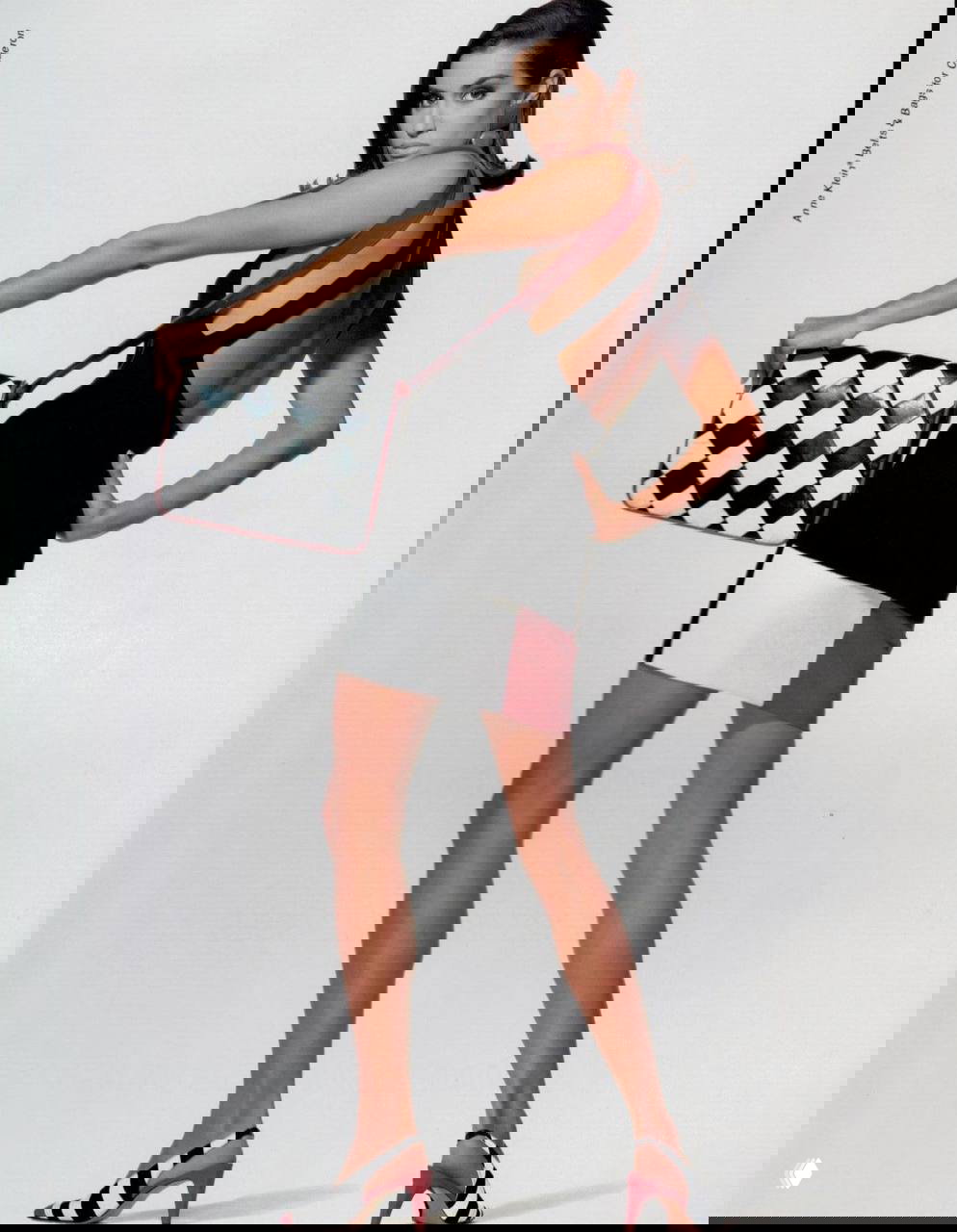 Ясмин Гаури в полный рост с сумкой в шахматный принт: элегантная поза и лёгкий ретро‑шик из кампании Anne Klein.