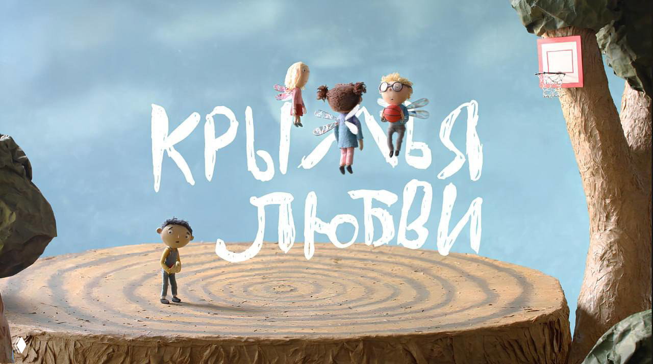 Кадр из анимационного короткометражного фильма «Крылья любви»: три детские фигурки с крылышками парят над деревянным пнем, рядом крупная надпись названия.