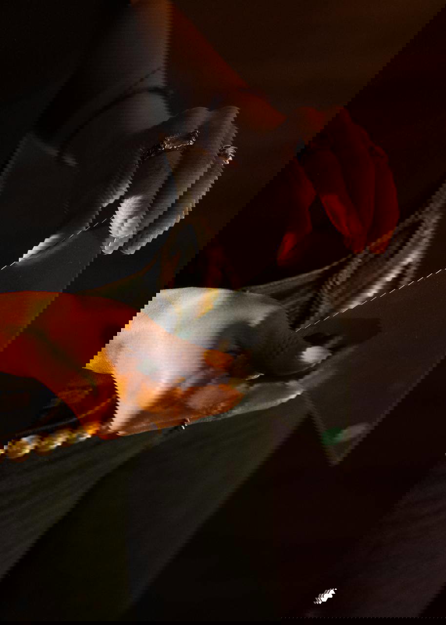 Крупный план рук человека, держащего треугольное зеркало или стекло в тёплом свете; деталь декора или реквизита, использованного на презентации.