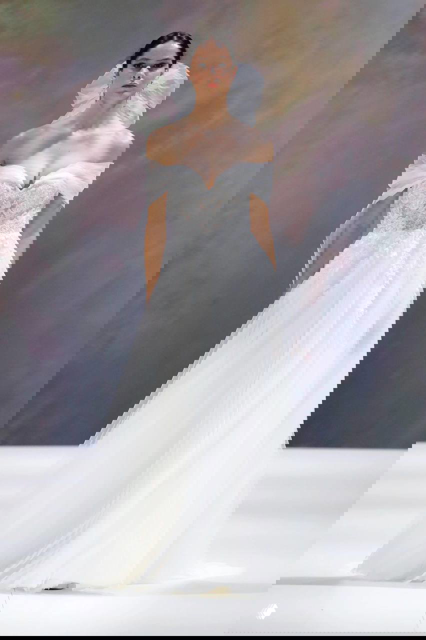 Модель в воздушном свадебном платье с корсетом и многослойной юбкой из тюля; образ нежный и кинематографичный, готовый к танцу.