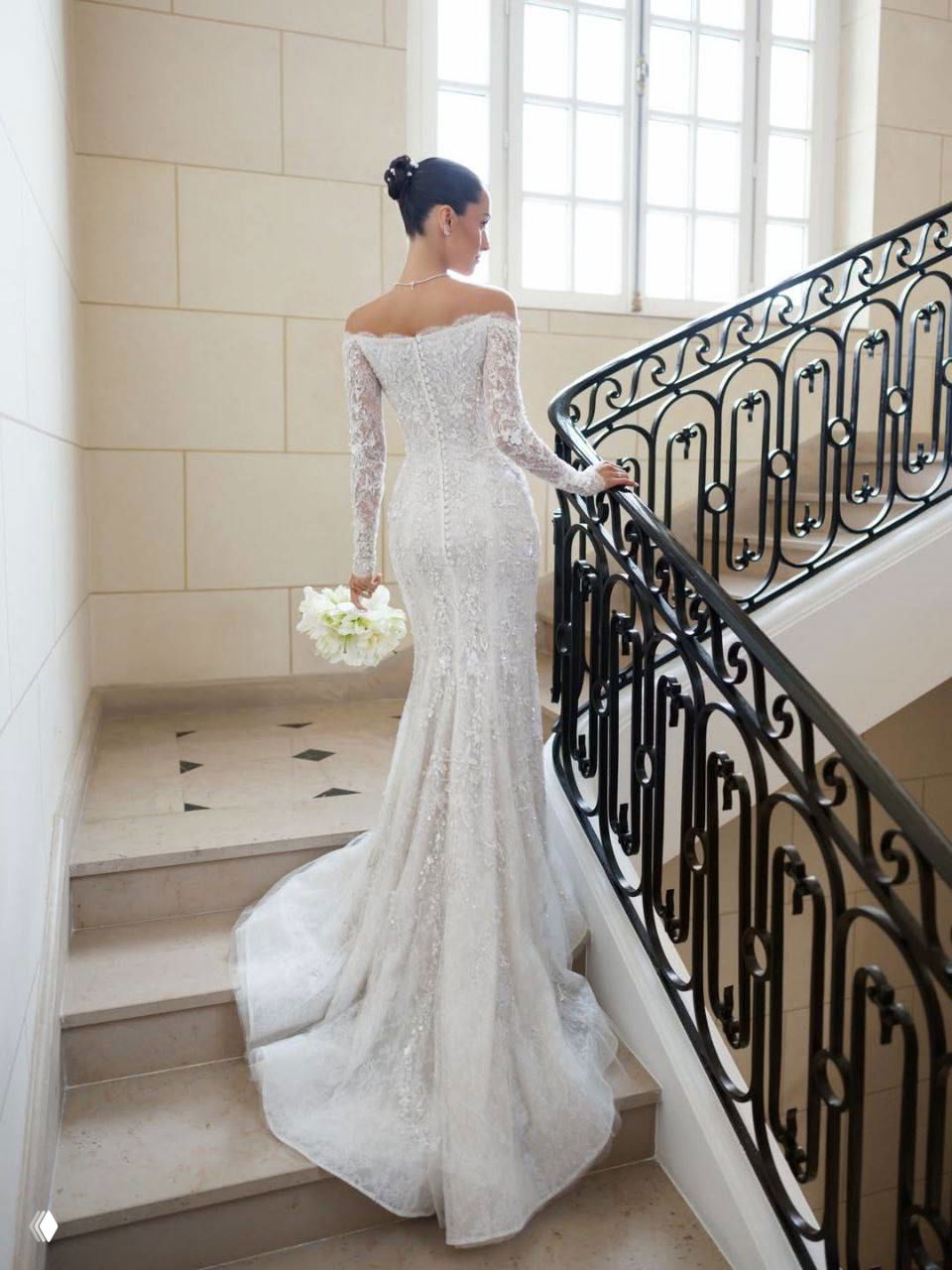 Невеста поднимается по мраморной лестнице: вид сзади на кружевное свадебное платье Paolo Sebastian, элегантная прическа и атмосфера дворцового интерьера в Монако.
