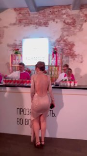 Барная стойка Schmidt с подсветкой и рядом напитки: бармены подают авторские коктейли, гости наблюдают, на переднем плане гостья у стойки в вечернем платье.