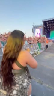 Короткое видео: зрительница у ограждения снимает выступление Нелли Фуртадо сзади; видно сцену, толпу и летнюю фестивальную атмосферу.