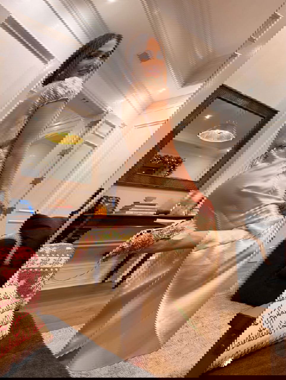 Дженнифер Лопес наряжает большую рождественскую ёлку в гостиной: золотые и розовые шары, гирлянды и уютная семейная атмосфера в доме.