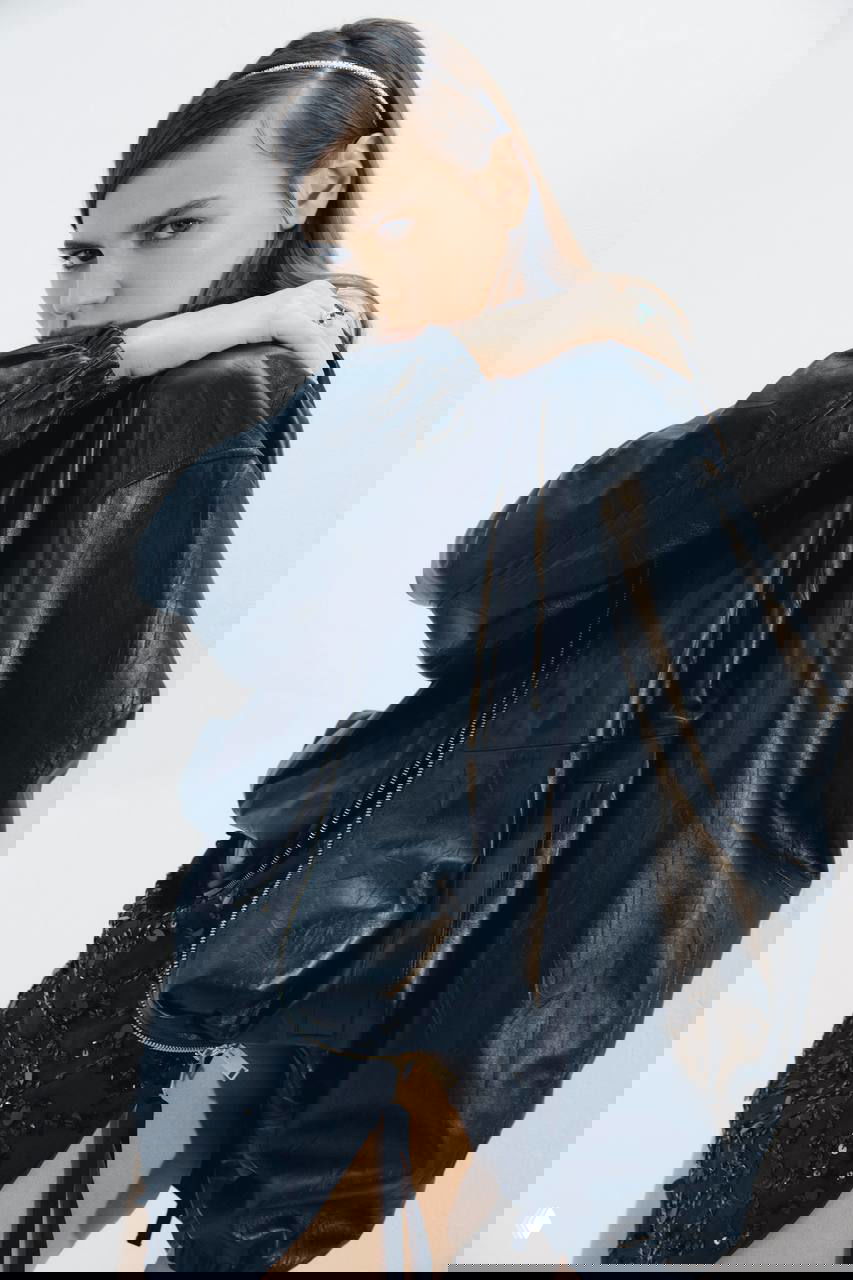 Модель Алина в кожаной куртке и юбке с пайетками, выразительный взгляд и минималистичный свет, модная съемка для журнала.