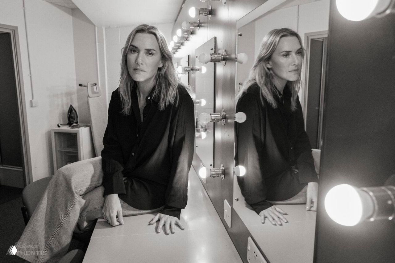 Актриса в гримёрке сидит у зеркала с лампочками: чёрно‑белый портрет, отражение в зеркале и приглушённый свет.