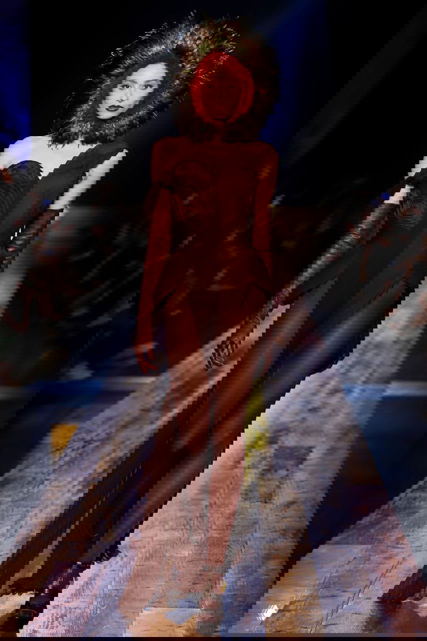 Модель в коричневом асимметричном платье с массивным воротником на подиуме — образ шоу Jean Paul Gaultier, сезон 2016.