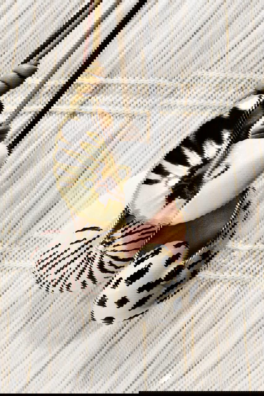 Крупный план подвесок и раковин в естественной цветовой гамме: керамические и металлические элементы на шнурках, морской мотив в деталях.