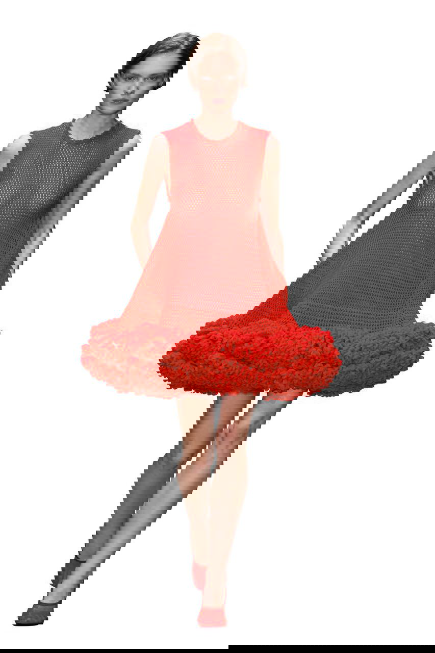 Модель в текстурном алом платье с пышным и фактурным низом: сетчатый верх и выразительный силуэт, акцент на материале и форме.