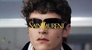 Крупный план модели в солнцезащитных очках и с логотипом Saint Laurent на экране — кадр из осенней кампании бренда 2026, рекламный ролик.