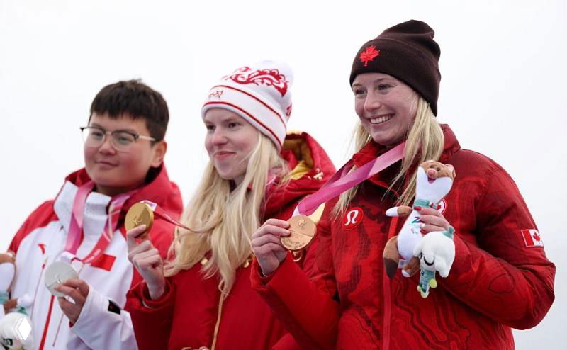 Паралимпийская церемония награждения на подиуме: несколько спортсменов с медалями и мягкими эмоциями после вручения призов.