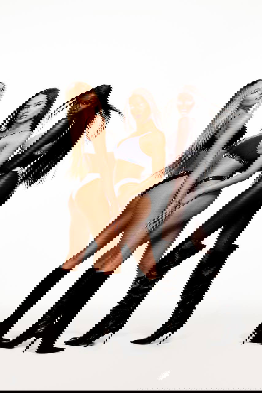 Три модели в профиль и анфас демонстрируют бельё Victoria’s Secret и высокие сапоги, подчёркивая силуэты на белом фоне.