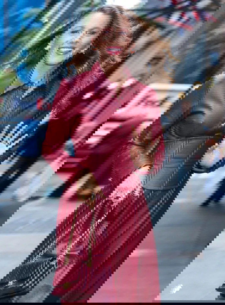 Крупный план: Блейк Лайвли улыбается в винном кожаном луке с сумкой и украшениями во время прогулки по Нью-Йорку.