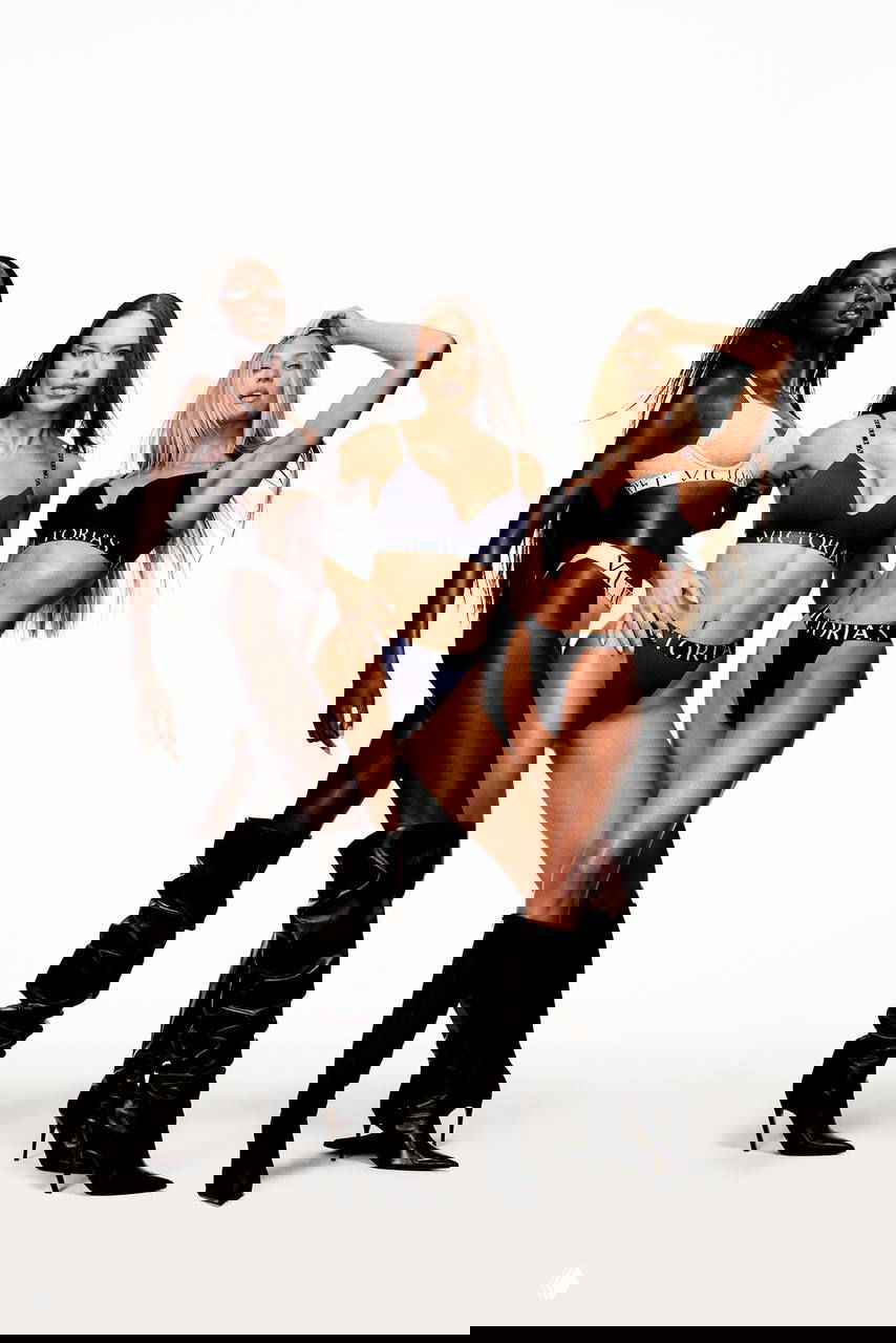 Три модели в комплектном белье Victoria’s Secret позируют в студии на белом фоне: акцент на силуэтах и высоких сапогах.