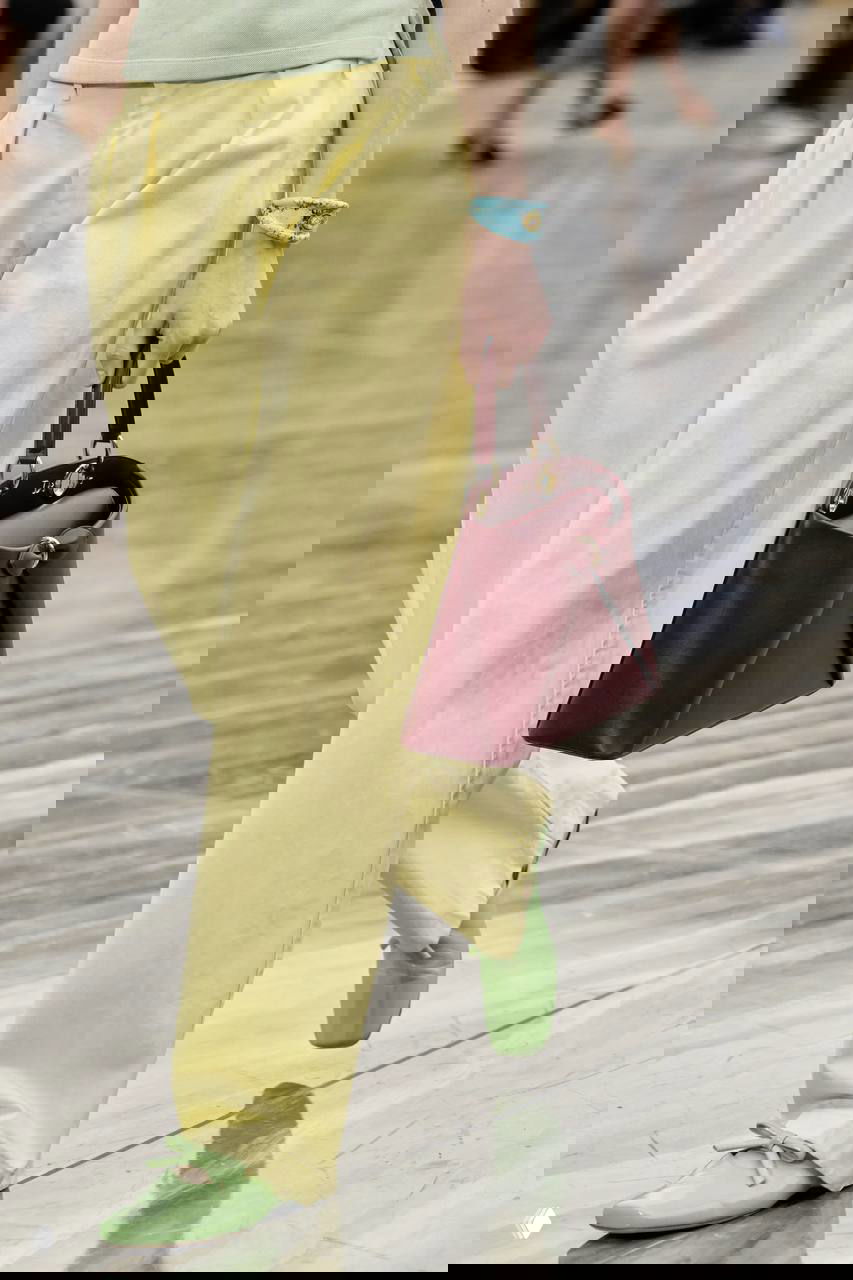 Модель в жёлтых брюках и бирюзовом браслете на запястье, кадр показывает сочетание яркой одежды с насыщенными природными аксессуарами.