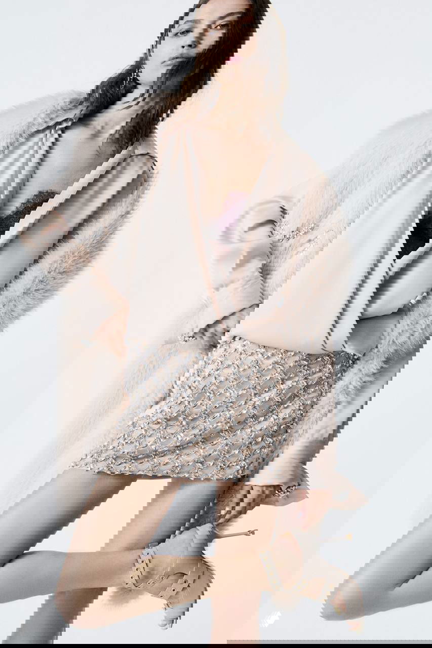 Образ в нежно-розовой палитре: шубка или накидка с пушистой текстурой, блуза и мини-юбка, украшенная стразами — романтическая фактура и блеск.