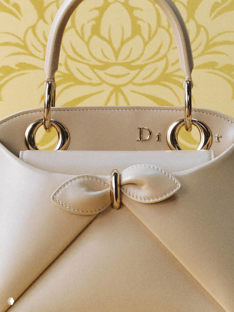 Модель стоит у стенда Dior с бордовой сумкой Cigale в руке, полный рост демонстрирует сочетание сумки с образом и длину ремня.