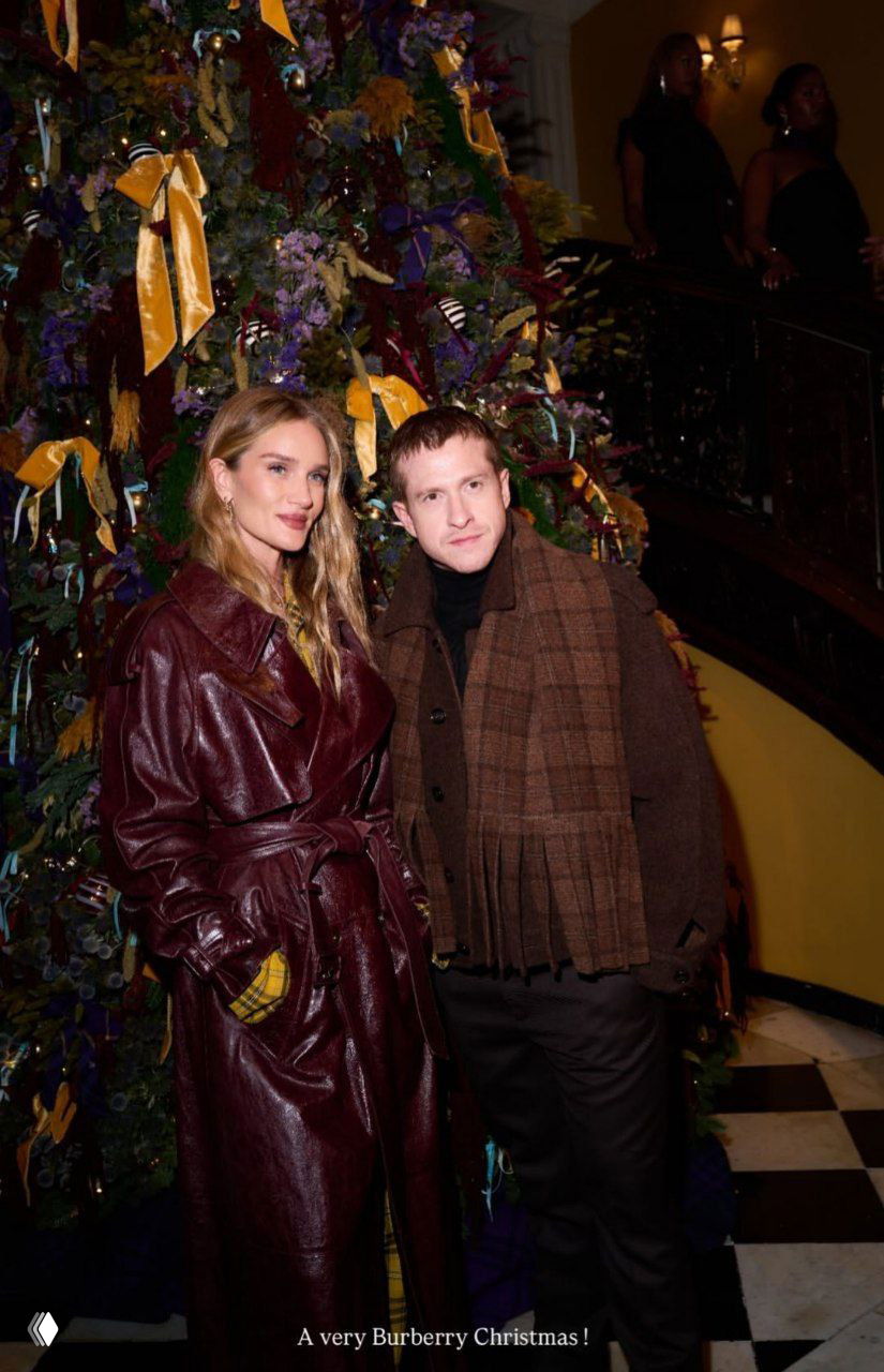 Позолоченные декоративные фигуры на переднем плане и высокая украшенная ёлка на лестничной площадке отеля с яркими лентами.