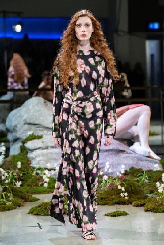 Модель в тёмном платье с крупным цветочным принтом, выполненным с заблюренным эффектом, демонстрирует принт на подиуме Патрика Макдауэлла.