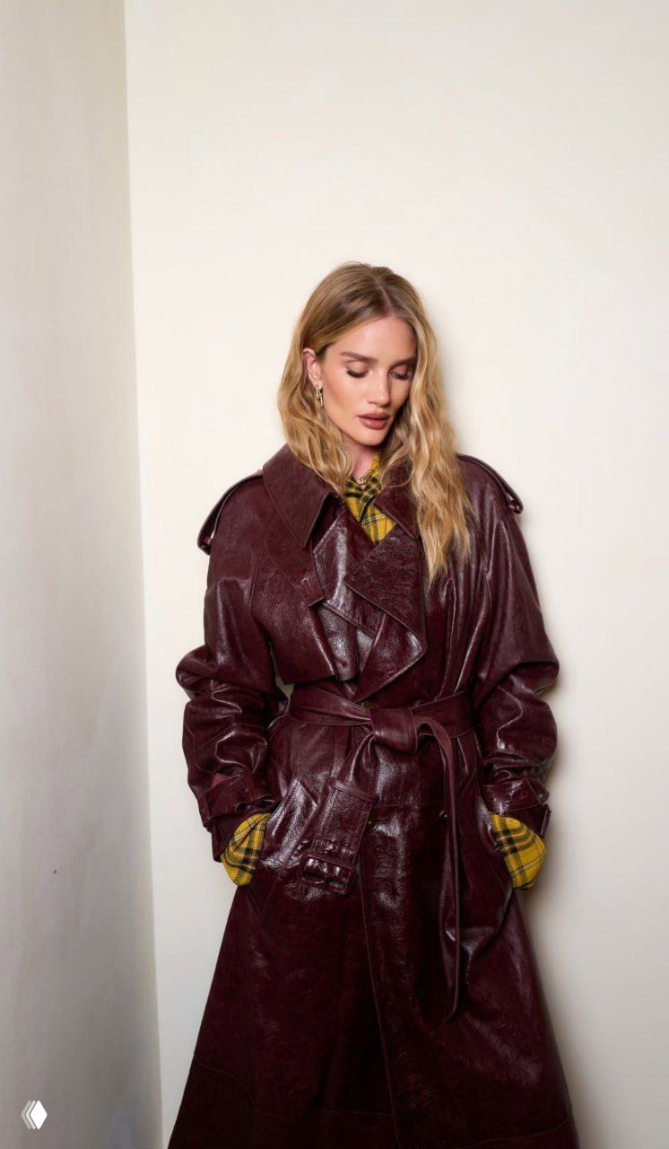 Пара гостей позирует у украшенной ёлки: женщина в тёмном пальто и мужчина в коричневом шарфе на фоне рождественской инсталляции.