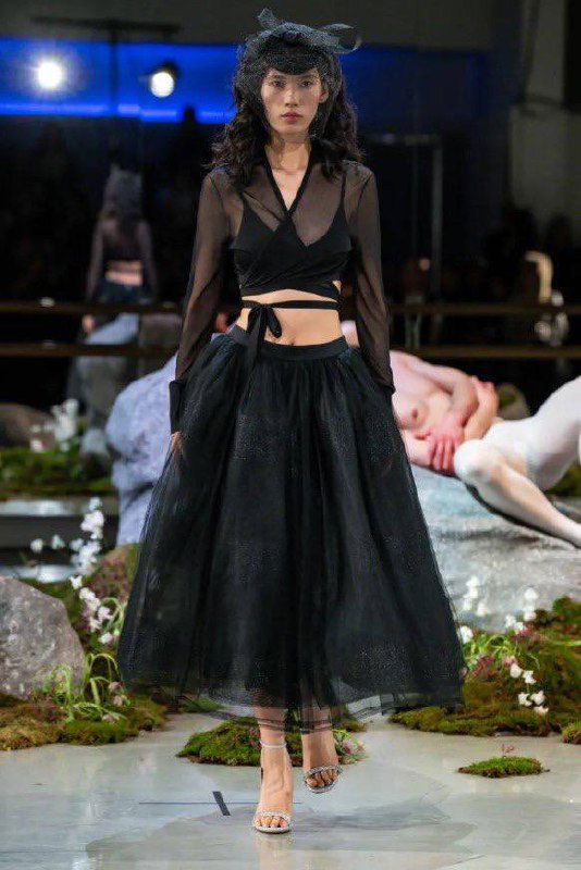 Модель в чёрном многослойном платье с прозрачным верхом и шляпкой — аксессуары созданы вместе с известным миланским шляпником Филипом Трейси.