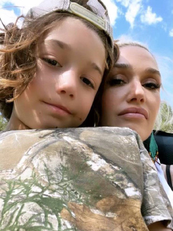 Селфи Гвен Стефани с сыном Аполло: крупный план их лиц на фоне голубого неба, естественное освещение и домашняя атмосфера.