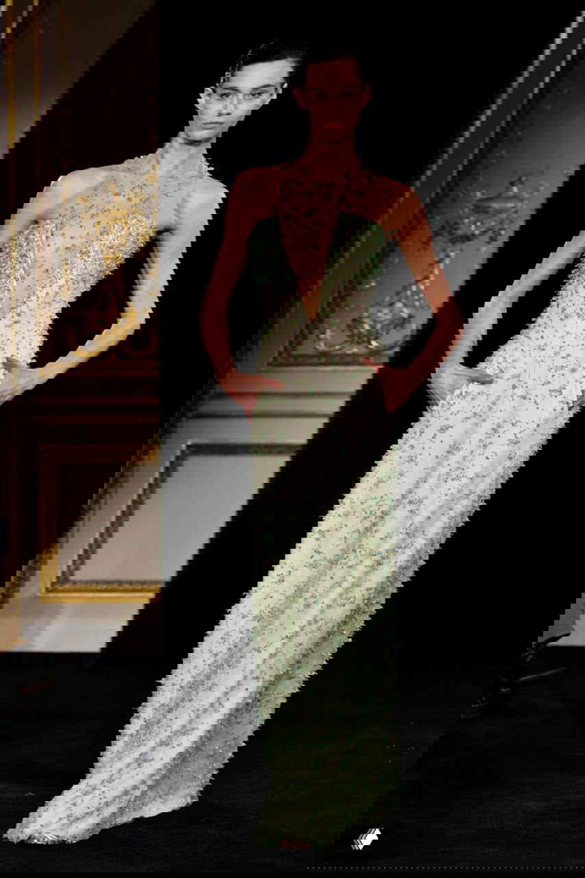 Элегантное вечернее платье мятного оттенка с глубоким вырезом и тонкими деталями декора на ткани, модель демонстрирует струящийся силуэт кутюрной работы Armani.