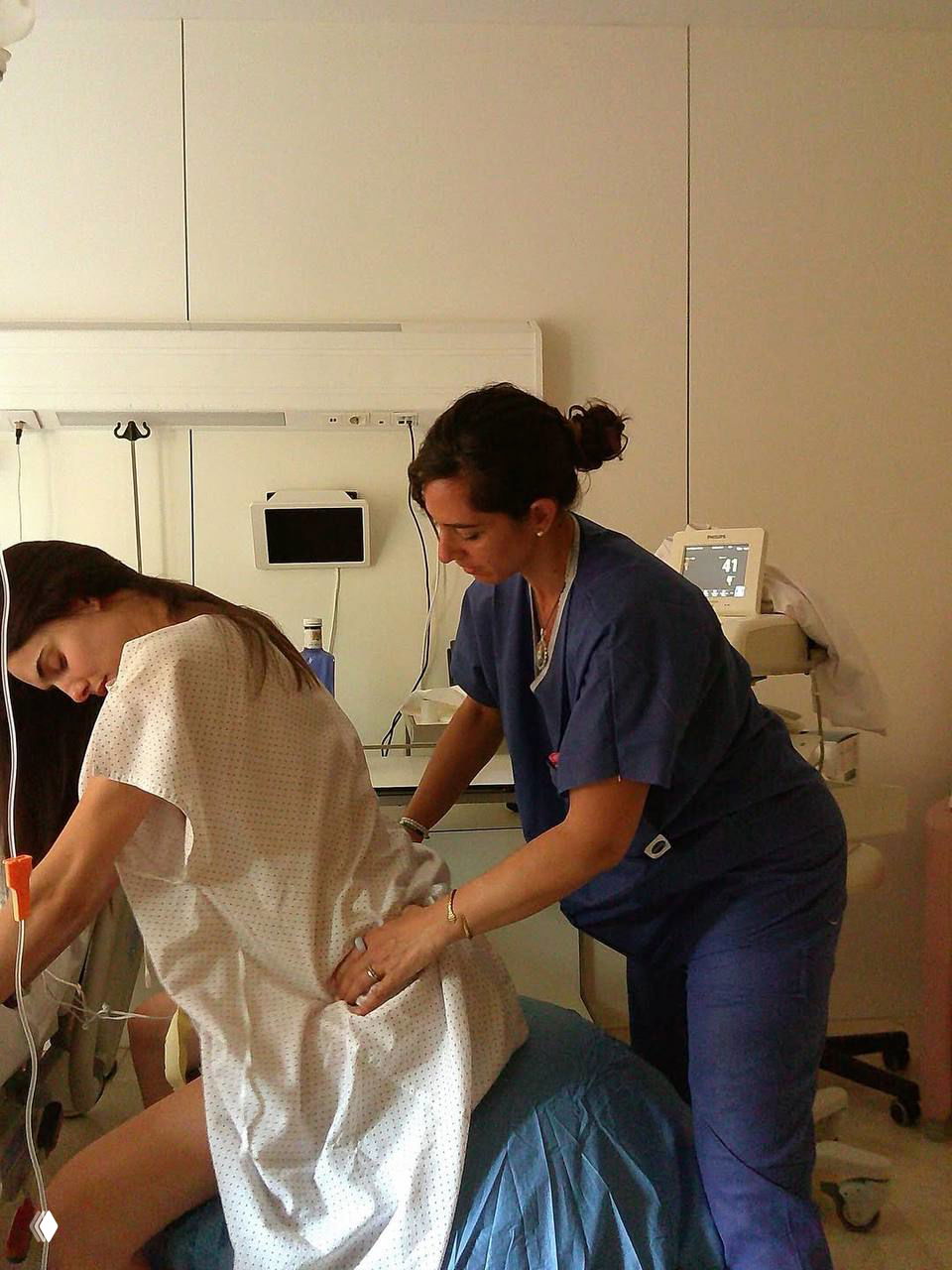 Момент в роддоме: Бланка Падилья во время родов под наблюдением медицинского персонала, кадр из клинической обстановки.