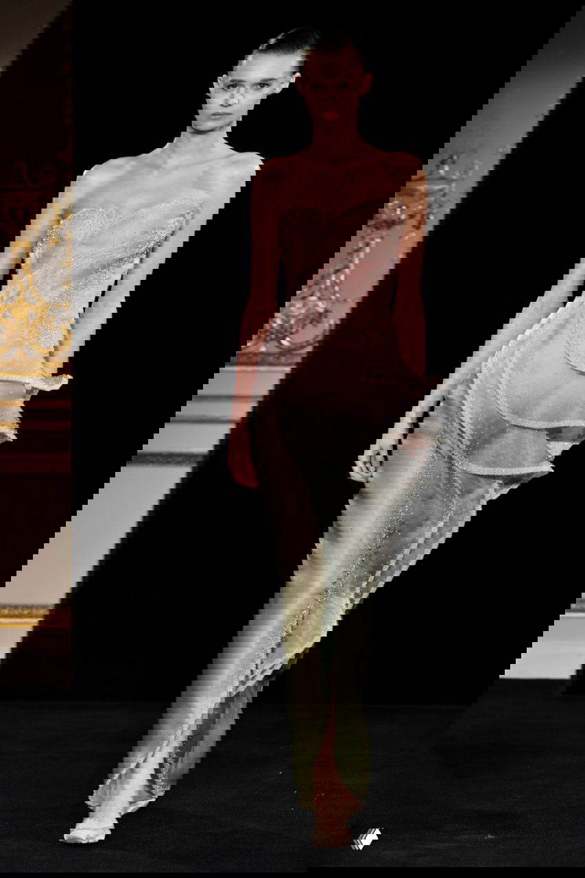 Воздушное мятно-пастельное платье с многослойной юбкой и тонким корсетом, образ кутюрного уровня от Giorgio Armani на тёмном подиуме и классическом интерьере зала.