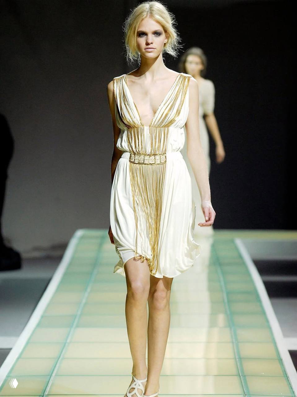 Показ архивного короткого платье Alberta Ferretti весна 2008: модель на подиуме в светлом платье с драпировкой и бахромой.