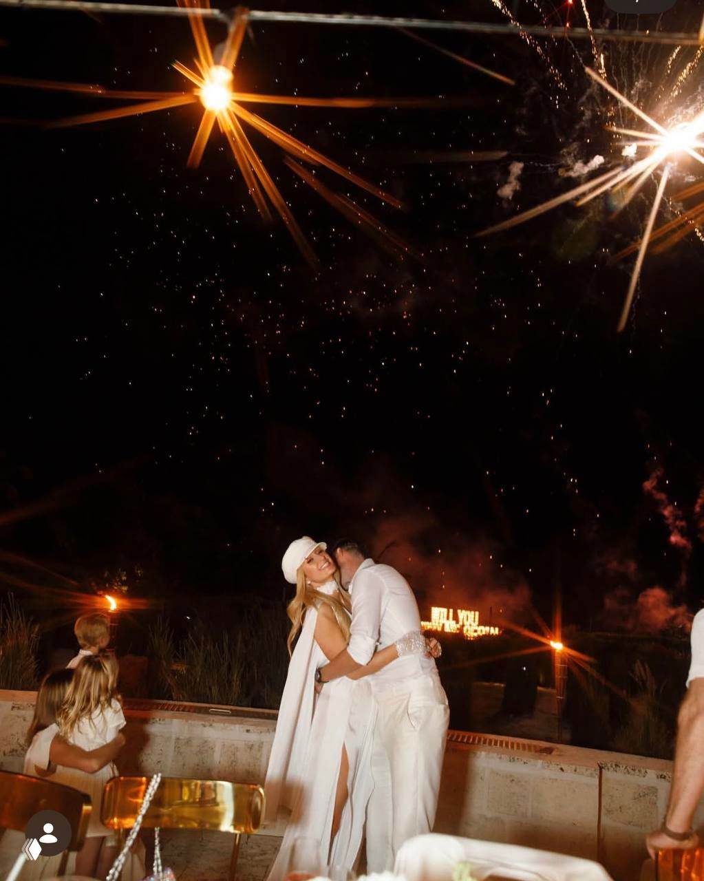 Перис Хилтон и Картер Рум обнимаются на фоне фейерверков и праздничного освещения — вечерняя часть торжества с огнями и эмоциями.